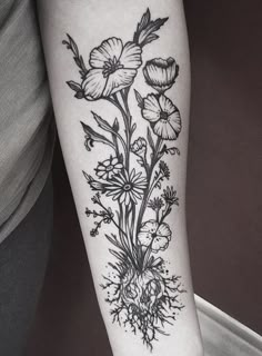 a black and white flower tattoo on the right arm, with flowers in it's center