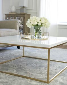 a coffee table with flowers on it in a living room