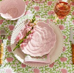 a table topped with pink plates and silverware