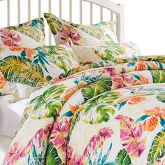 an image of a bed with colorful comforter and pillow set on it's side