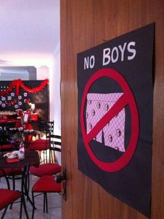 there is a no boys sign on the wall next to chairs and tables in this restaurant