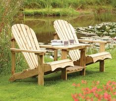 two wooden chairs sitting next to each other in the grass