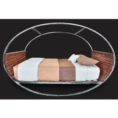 a bed that is sitting in the middle of a circular metal frame with two pillows on it