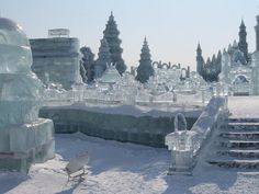 an ice sculpture is shown in front of some stairs and buildings with snow on them