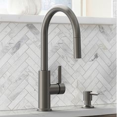 a kitchen faucet with two handles and nozzles on the counter top