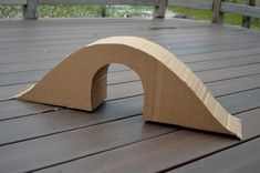 a cardboard arch sitting on top of a wooden deck