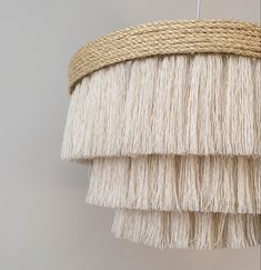 a close up of a light fixture with fringed material on it's sides