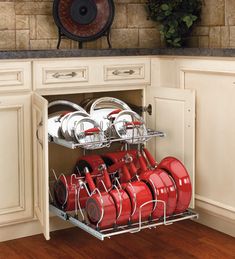 the kitchen space saver is open to show red pots and pans