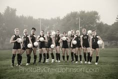 a group of people standing on top of a field holding soccer balls in their hands