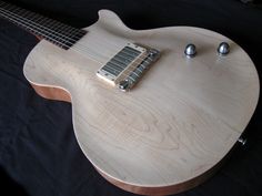 an electric guitar is sitting on a black background with its fretboard and neck missing