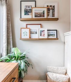 three wooden shelves with pictures on them above a dresser and chair in a living room