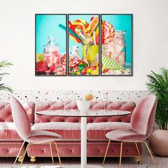 two paintings on the wall above a pink couch in a room with chairs and table