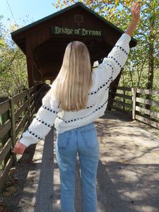 a woman standing on a bridge with her arms in the air