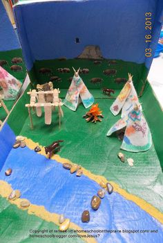 a play area with tents, rocks and animals on the ground in front of a blue wall