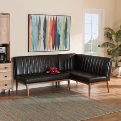 a black leather couch sitting on top of a wooden floor next to a coffee maker