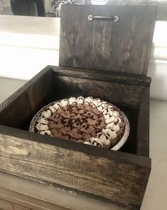 a wooden box with a cake inside of it