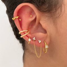 a woman wearing ear piercings with gold chains