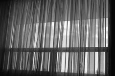 black and white photo of curtains in front of a window