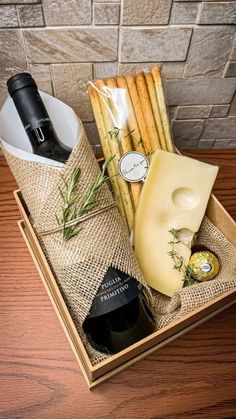 a wooden box filled with cheese, crackers and other items on top of a table