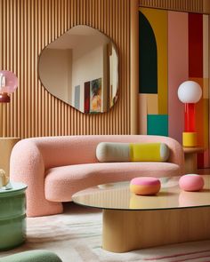 a living room filled with furniture and a round mirror on the wall over a coffee table