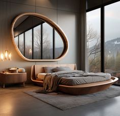 a large bed sitting next to a tall window in a bedroom under a round mirror