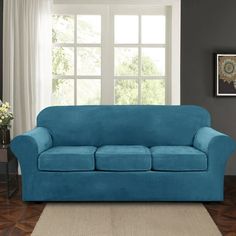 a blue couch sitting in front of a window