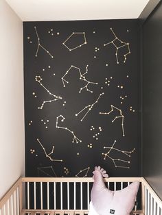 a baby's room with stars painted on the wall and a crib in front of it