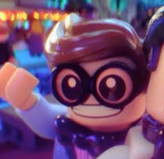 the lego batman movie character is holding his fist up in front of another character wearing a costume