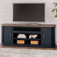 a flat screen tv sitting on top of a wooden entertainment center