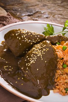 a white plate topped with rice and meat covered in gravy