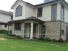 a house that is in the grass with windows on each side and one door open