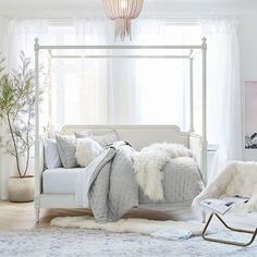 a white bed with fluffy blankets and pillows