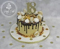 a birthday cake with chocolate icing and nuts on top is decorated with gold polka dots