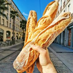 a person holding up some bread in their hand