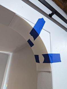 blue tape is taped to the side of a white door