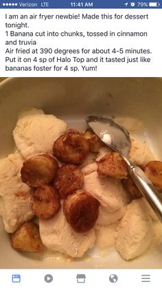 a bowl filled with bananas and ice cream on top of a table next to a spoon