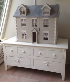 a doll house sitting on top of a dresser