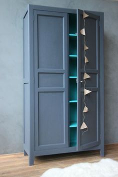 an armoire with blue shelves and white rug