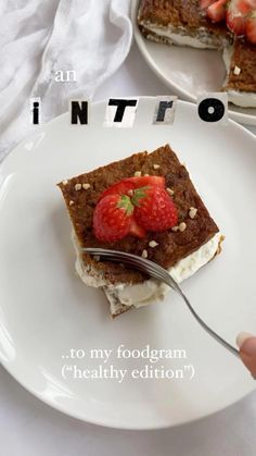 a white plate topped with cake covered in strawberries