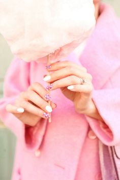 a woman in pink coat holding cotton candy