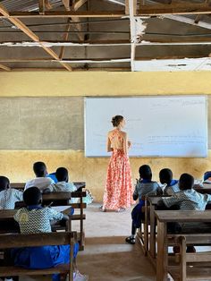 a woman standing in front of a classroom full of students