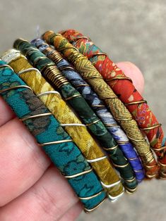 Stack up on these colorful & bold boho bangles!  I wrap each bracelet by hand with unique upcycled sari silk and finish with a wire wrap to secure.  Add vintage kuchi coin charms to a few or all to complete the look, These bracelets are a super simple and lightweight for easy, comfortable wear. Select one or mix and match to create your own personalized set! ★ Handmade ★ Upcycled Sari Silk ★ Non-Tarnish Wire ★ Vintage Kuchi Coin Charm ★ 65mm inner diameter ✉ Message for Custom Requests ✈ Free Sh Handmade Green Wrap Bangle Bracelet, Bohemian Multicolor Wire Wrapped Beaded Bracelets, Bohemian Adjustable Wire Wrapped Bangle, Adjustable Multicolor Spiritual Bangle, Multicolor Hand Wrapped Hippie Wrap Bracelet, Artisan Adjustable Bangle For Festivals, Multicolor Wire Wrapped Bangle Bracelets, Multicolor Hand Wrapped Bangle Bracelets, Handmade Bohemian Bangle Cuff Bracelet