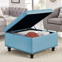 a small blue ottoman with an open lid