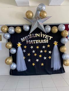 a bulletin board with balloons and tassels in the shape of stars on it