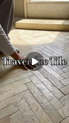 a person kneeling down on the ground with their foot in front of a tile floor