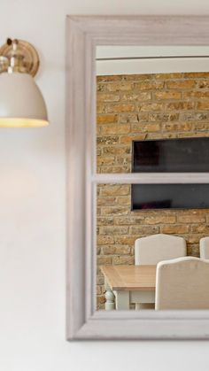 a mirror reflecting a dining room table and chairs