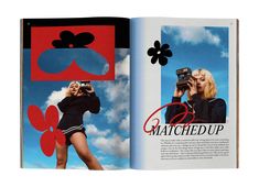 an open book with images of women in black and red on the pages, one is holding a camera