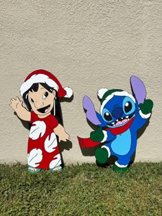 two cartoon characters standing next to each other in the grass near a wall and one is wearing a santa hat