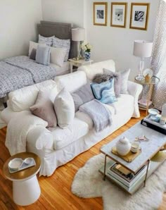 a living room filled with white furniture and pillows