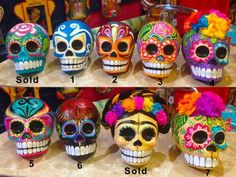 several different colored skulls with flowers on their heads and numbers in the middle one is for sale